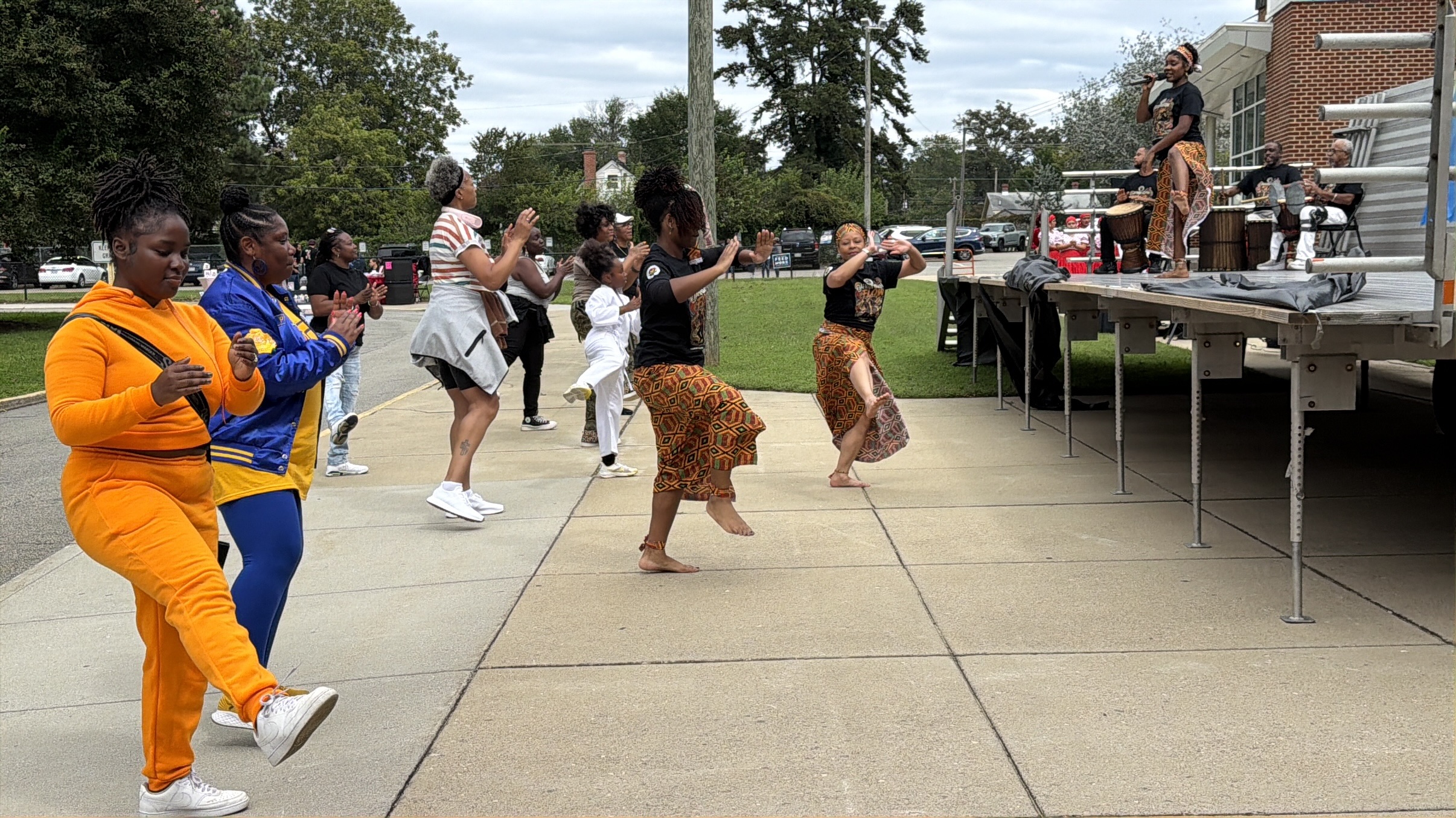 Community members joining AfroFusion dancers in an outdoor dance activity
